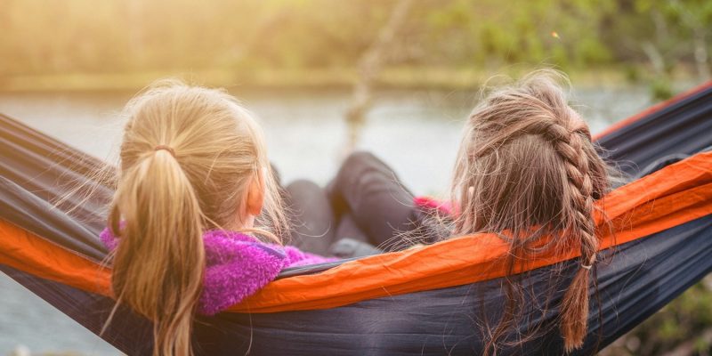 two women lying on hammock